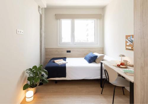 een kleine slaapkamer met een bed en een raam bij Yugo Terrassa Can Telar in Terrassa