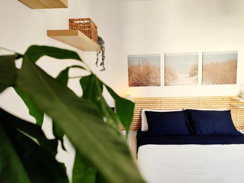 a bedroom with a bed with blue pillows and a plant at Almarea Beach - Essenza del mare, calore di casa in Imperia