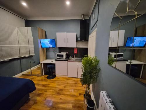 a small room with a kitchen with white cabinets at Dodi Aparts London, near Stratford close to tube station in London