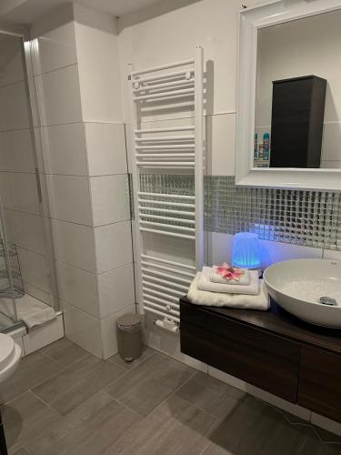 a bathroom with a sink and a mirror and a tub at Neue Erdgeschosswohnung in Zentrum von Rockenhausen in Rockenhausen