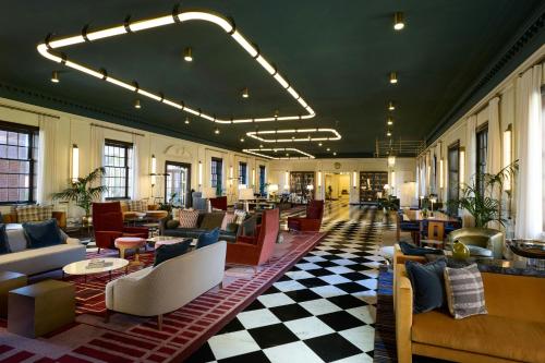 a lobby with couches and tables in a building at Dearborn Inn, Autograph Collection in Dearborn