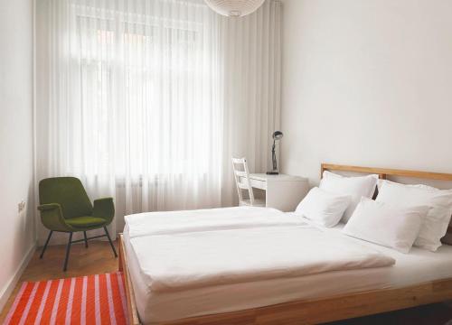 une chambre avec un lit, une chaise et une fenêtre dans l'établissement J Street Cozy Apartments - A2, à Gornji Grad