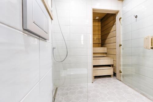 a bathroom with a walk in shower and stairs at Naava Chalet Loft - Kaksikerroksinen lasiseinähuoneisto järvinäköalalla in Ähtäri