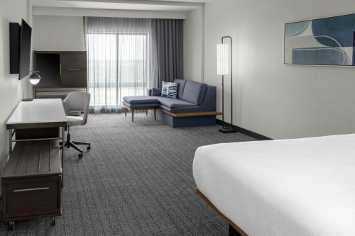 a hotel room with a bed and a desk at Courtyard by Marriott Sherman in Sherman
