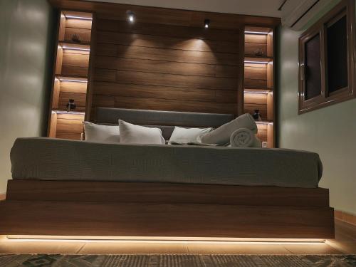 a bedroom with a large bed with a wooden headboard at Tahrir apartments in Cairo