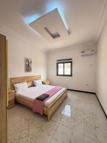 a bedroom with a large bed in a room at Immeuble Sali Laye in Darou Rhamane