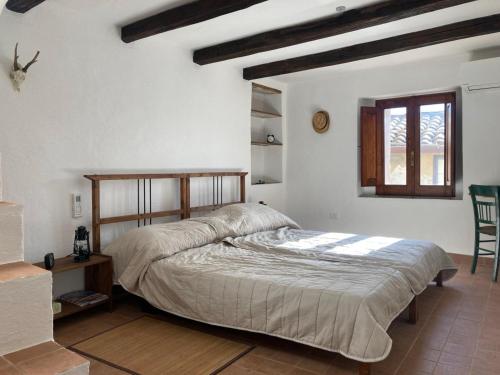 a bedroom with a bed and a window at Nina's House , nonna Lucia in Badolato