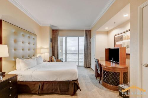 拉斯维加斯MGM Signature-33-714 1BR 2-Bath Balcony Suite的一间卧室，里面有一张床、一张桌子和一台电视。
