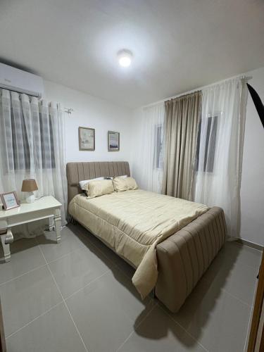 a bedroom with a large bed and a table at Apartamento amplio con piscina 