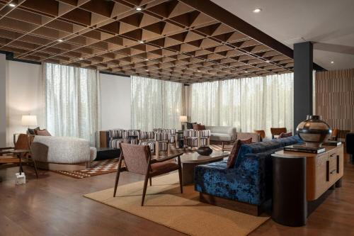 a living room with chairs and a couch and tables at The Elmore Hotel, DFW Southlake, a Tribute Portfolio Hotel in Southlake