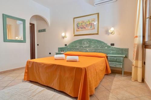 una habitación con una cama verde con una sábana naranja en Residence con piscina a Sos Alinos, en Cala Liberotto
