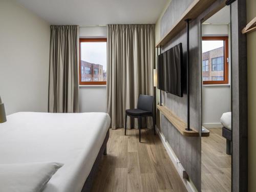 a hotel room with a bed and a tv at ibis budget Swindon in Swindon