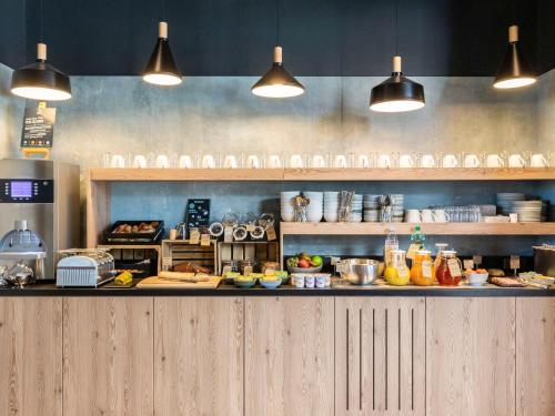 a kitchen with a counter with food on it at Aparthotel Adagio access Palaiseau Saclay in Palaiseau