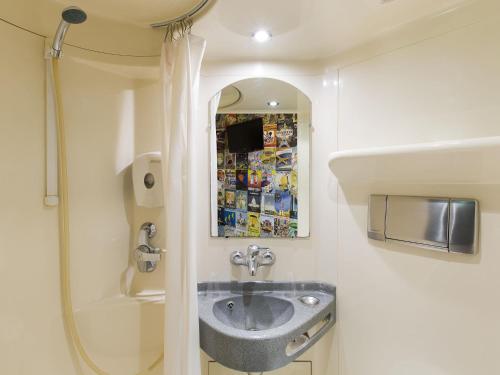 a bathroom with a sink and a mirror at HOTEL F1 Lyon Genay Massieux in Massieux