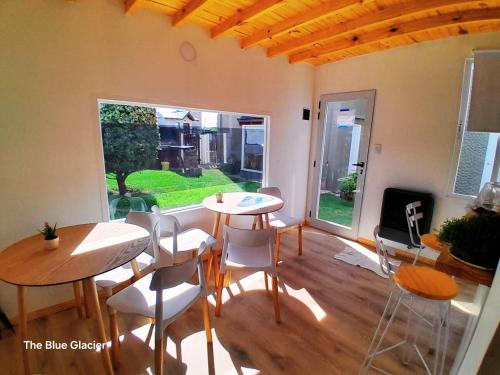 エル・カラファテにあるTHE BLUE GLACIERのテーブル2台と椅子、窓が備わる客室です。