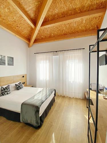 a bedroom with a bed and a wooden floor at Hotel Entrerailes in Casalarreina