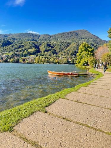 La Casa di Erika في Monasterolo del Castello: وجود قارب جالس على الماء بجانب جبل