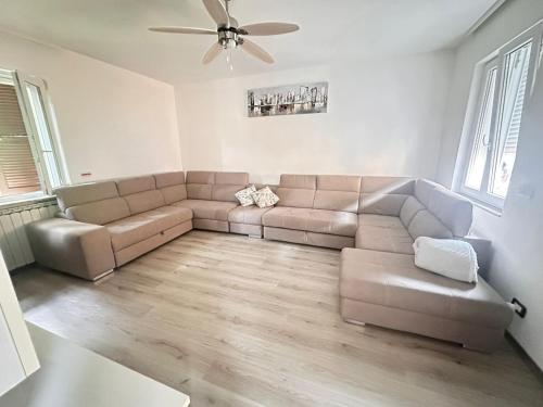 a living room with a couch and a ceiling fan at La Casa di Erika in Monasterolo del Castello