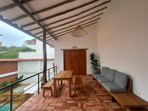a patio with a couch and a table on a balcony at Casa Mónica Barichara in Barichara
