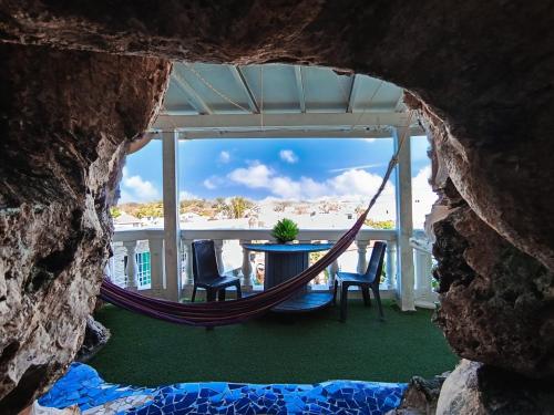 a hammock on a porch with a table and chairs at The Rock House Eco in San Andrés