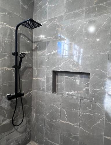a bathroom with a shower with a stone wall at Mi refugio 2 in San Fernando de Monte Cristi