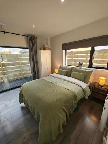 a bedroom with a large bed with a large window at Modern and peaceful, country retreat in Lahinch