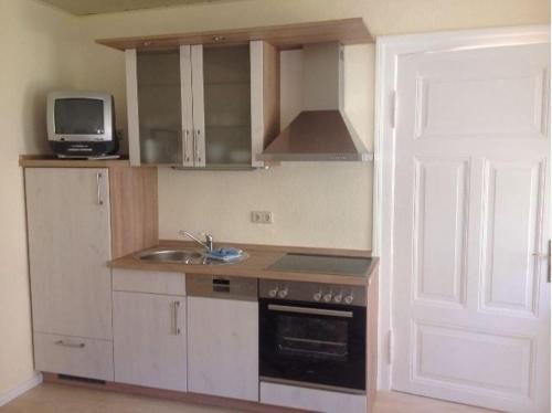 a kitchen with a sink and a stove and a microwave at Ferienwohnung Kati in Zinnowitz