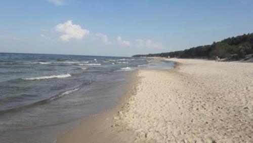 une plage de sable avec l'océan en arrière-plan dans l'établissement Ferienwohnung Kati, à Zinnowitz