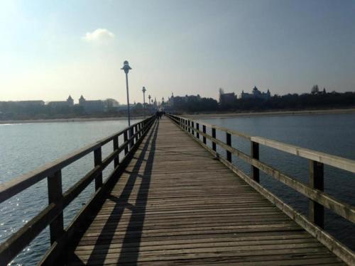 a wooden boardwalk stretches out over the water at Ferienwohnung Kati in Zinnowitz