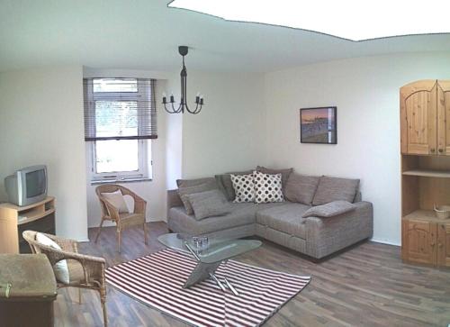 a living room with a couch and a tv at Ferienwohnung Julia in Zinnowitz