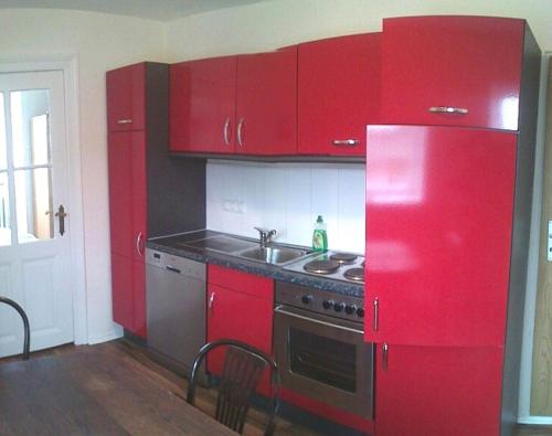 a red kitchen with a stove and a red refrigerator at Ferienwohnung Julia in Zinnowitz