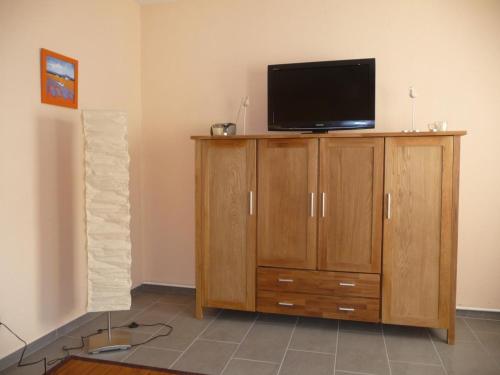 a tv sitting on top of a wooden cabinet at Ferienhaus Emma in Zinnowitz