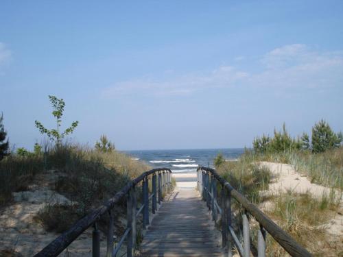 a wooden path leading to a beach with the ocean at Ferienwohnung Ida in Ahlbeck