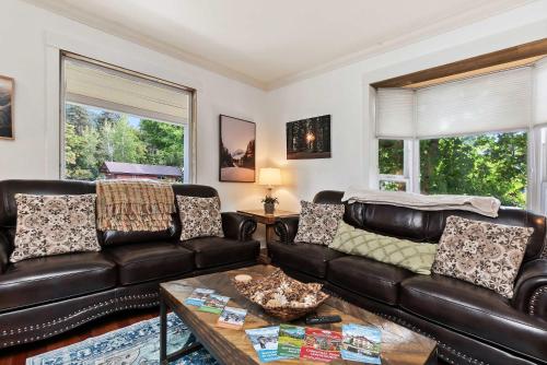 - un salon avec un canapé en cuir et 2 fenêtres dans l'établissement Downtown BnB House - Hot Tub - Barrel Sauna, à Leavenworth