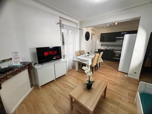 sala de estar con TV y mesa y cocina en Charme Médiéval à Provins, en Provins