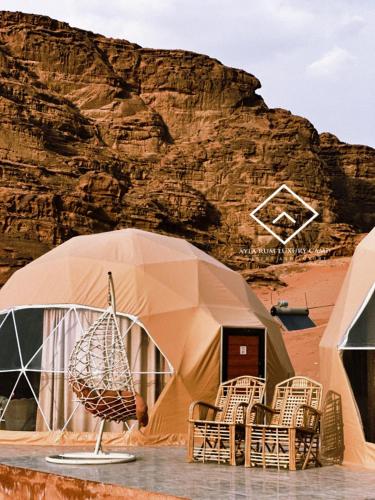 a tent with chairs in front of a mountain at ALYA RUM LUXURY Camp in Wadi Rum