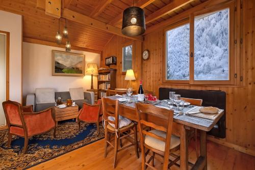 una sala da pranzo con tavolo e sedie di Chalet du Glacier - Happy Rentals a Chamonix-Mont-Blanc