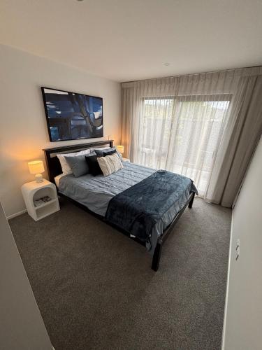 une chambre avec un lit et une grande fenêtre dans l'établissement Brand New, Bright & Private Silverstream Stay, à Upper Hutt