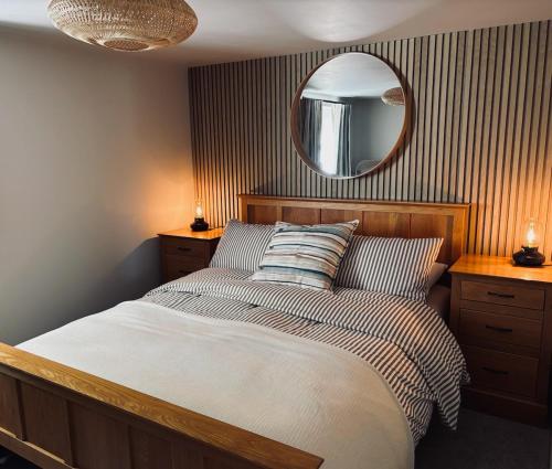 una camera da letto con un letto con uno specchio sul muro di Hanger Farmhouse Hideaway a Totton and Eling