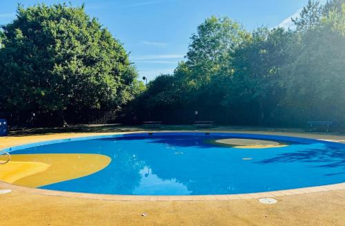 una grande piscina di acqua blu in un parco di Hanger Farmhouse Hideaway a Totton and Eling