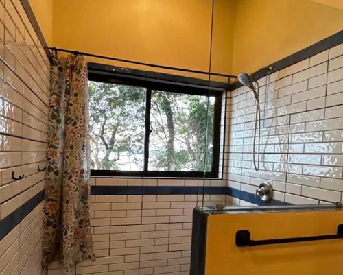 a bathroom with a window and a tub with a shower at Finca Ometepe in Balgue