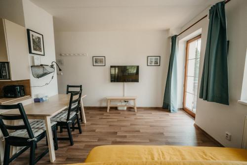 a room with a table and chairs and a tv at Rezidence Rokytnice in Rokytnice nad Jizerou