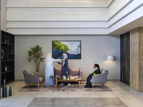 a rendering of a lobby with two women sitting in chairs at Adagio Aparthotel Jeddah Malik Road in Jeddah
