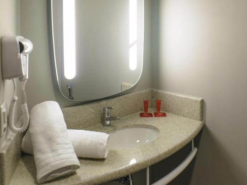 um banheiro com uma pia e um espelho em ibis Itatiba em Itatiba