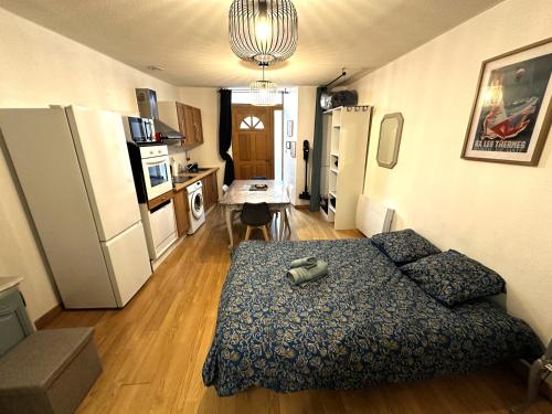 appartement T2 RDC في آكس ليه تيرم: غرفة معيشة صغيرة بها أريكة ومطبخ