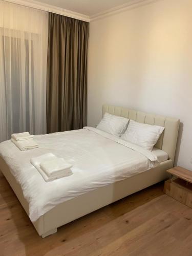 a white bed with two white towels on it at Apartament in Ipotești in Ipoteşti