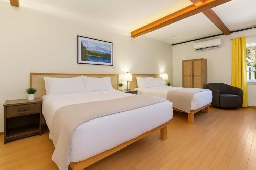 une chambre d'hôtel avec deux lits et une chaise dans l'établissement Snowcreek-Downtown-Dogwood-HotTub-Kitchenette, à Leavenworth