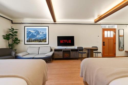 une chambre d'hôtel avec deux lits et une télévision dans l'établissement Snowcreek-Downtown-Dogwood-HotTub-Kitchenette, à Leavenworth