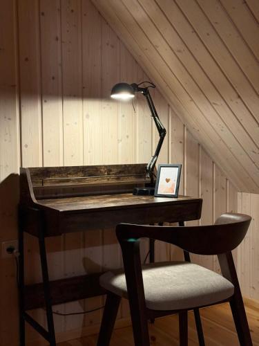 a desk with a lamp and a chair in a room at Rodzinna Przystań in Łupawa