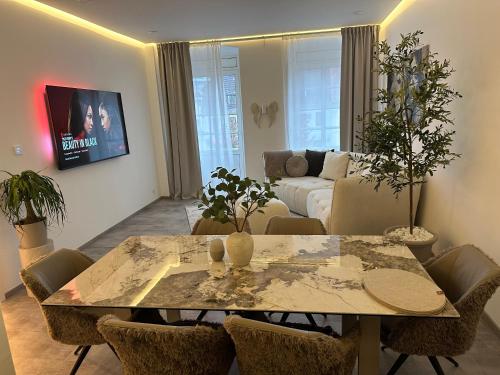 a living room with a table and a couch at Good Vibes Luxury Homes in Kaiserslautern